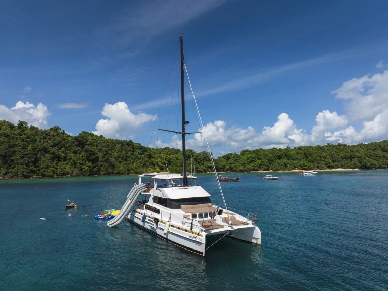 GANI luxury catamaran with water slide anchored at a Phuket island on a boat charter in Thailand