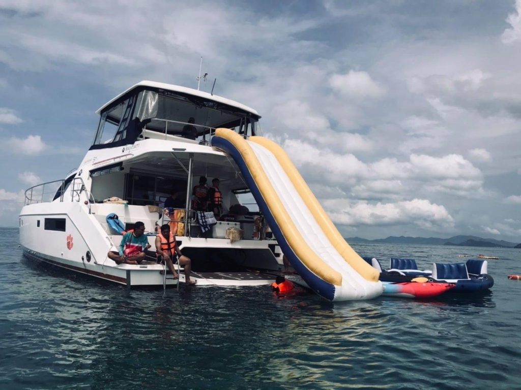Guests on the flybridge of the YATI power catamaran cruising Phuket