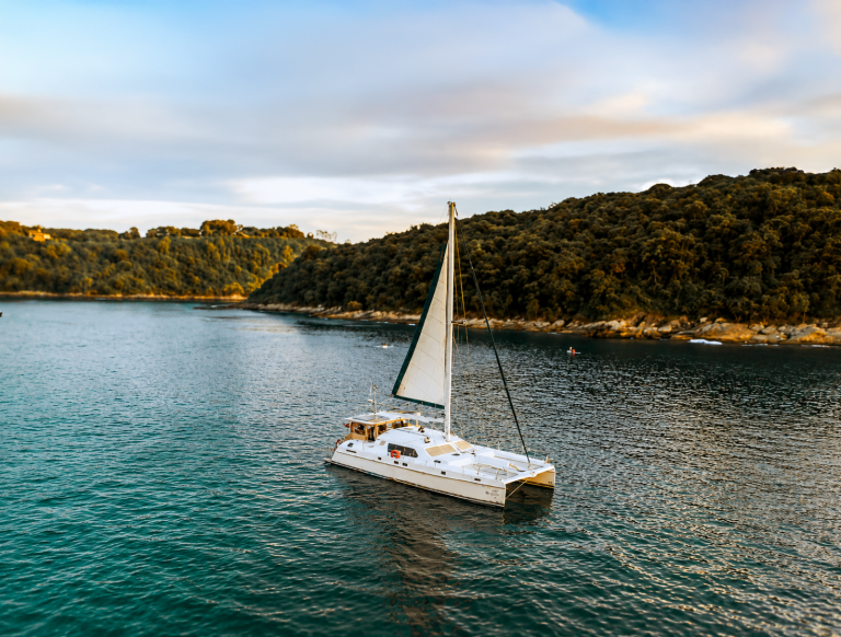ASTE luxury sailing catamaran anchored in a Phuket bay on a boat charter in Thailand