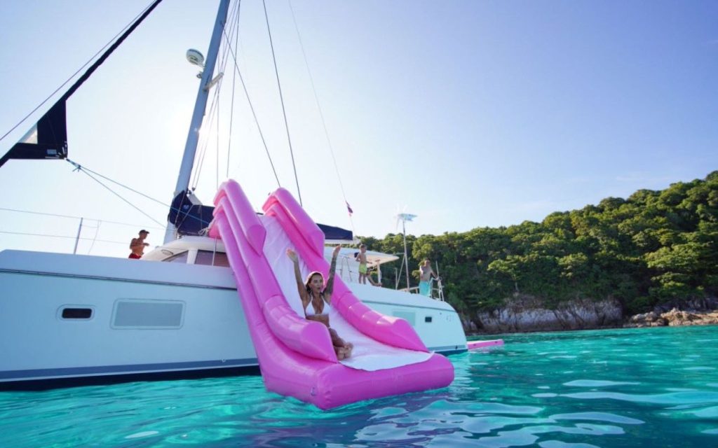 Guests enjoying the foredeck of the PEACHES catamaran during a Phuket island cruise